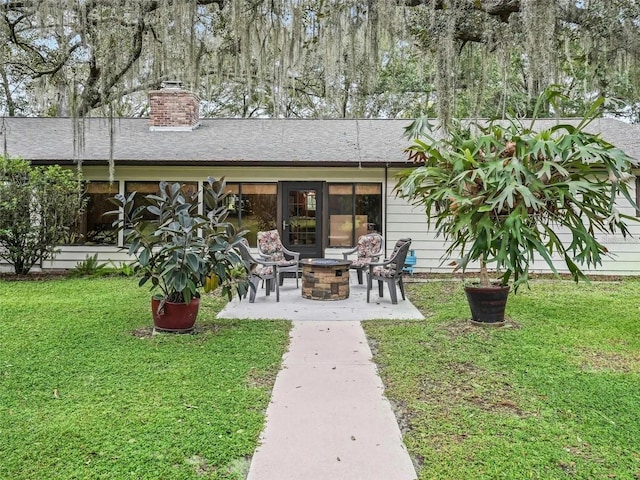 rear view of house featuring a yard and a fire pit