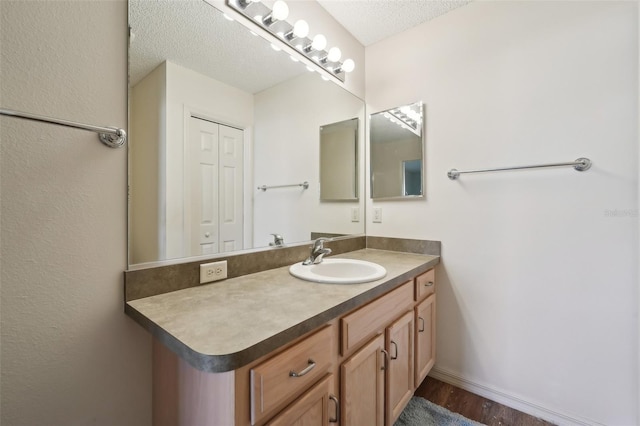 bathroom featuring vanity, hardwood / wood-style floors, and a textured ceiling