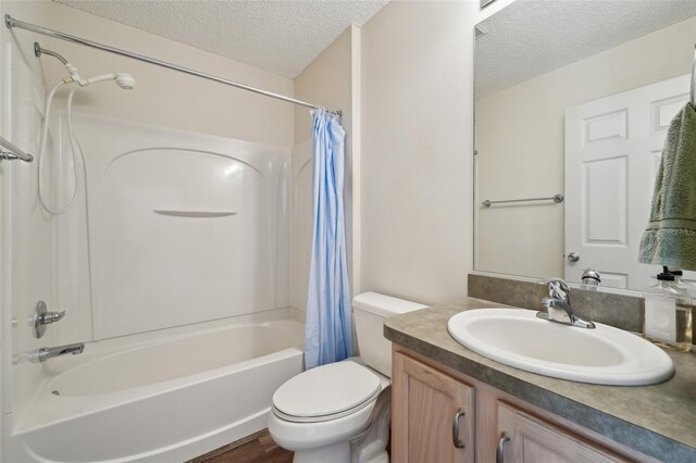 full bathroom with shower / bathtub combination with curtain, vanity, wood-type flooring, a textured ceiling, and toilet