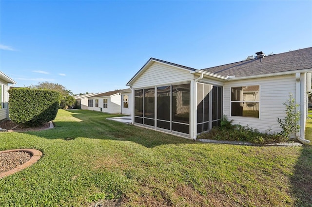 back of house with a sunroom and a lawn