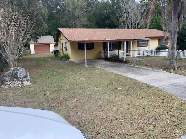 single story home with a porch, a front yard, and a carport