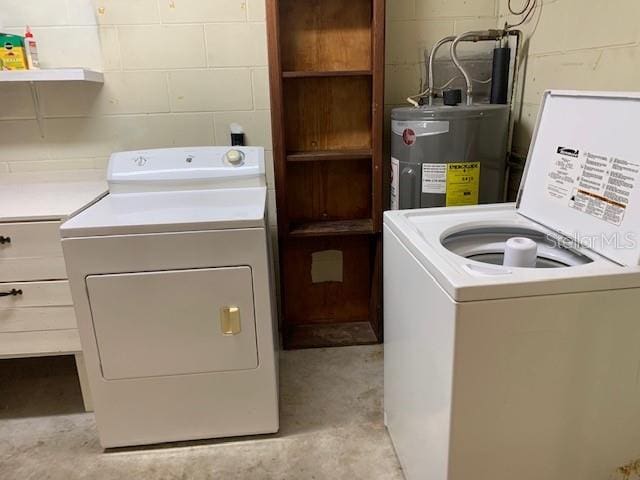 laundry room featuring washer and dryer, cabinets, and electric water heater