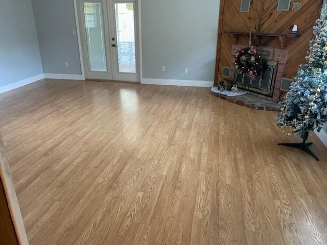 unfurnished living room featuring french doors and light hardwood / wood-style flooring