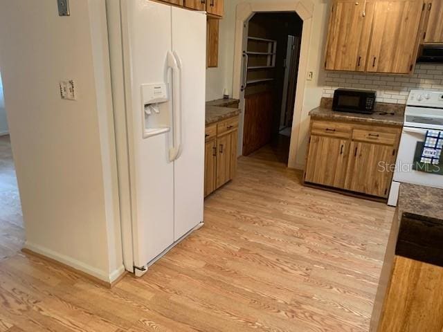 kitchen with backsplash, light hardwood / wood-style flooring, extractor fan, and white appliances