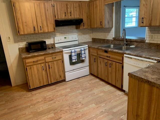 kitchen with decorative backsplash, white appliances, extractor fan, sink, and light hardwood / wood-style floors