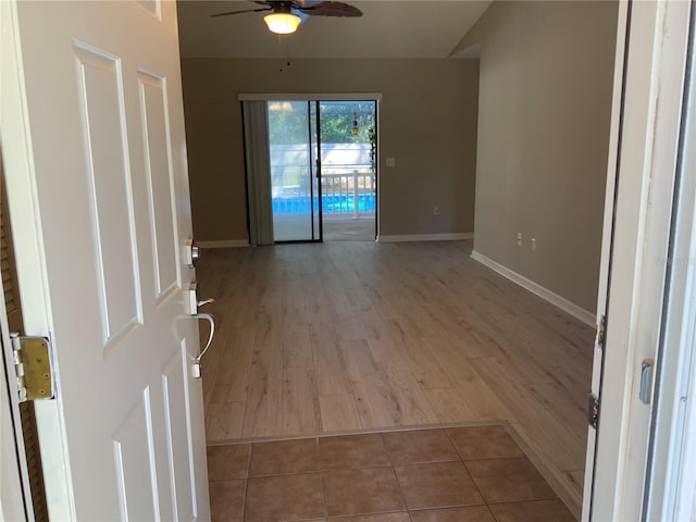 tiled spare room with ceiling fan