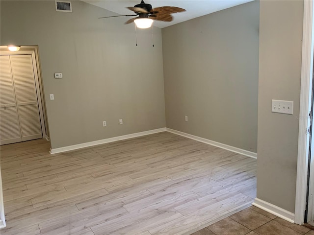 empty room with ceiling fan and light hardwood / wood-style flooring