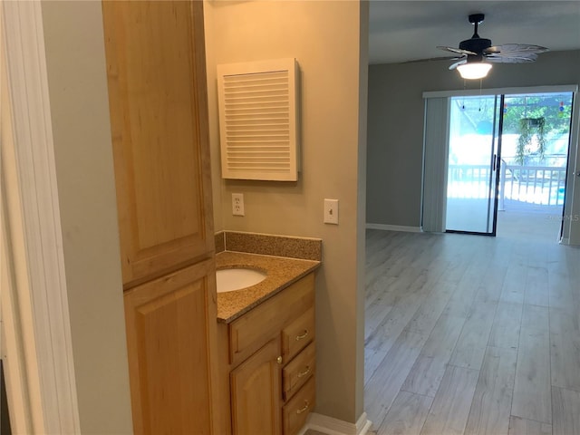 bathroom with hardwood / wood-style floors, vanity, and ceiling fan