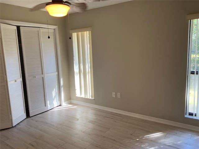 unfurnished bedroom featuring ceiling fan, light hardwood / wood-style floors, and a closet