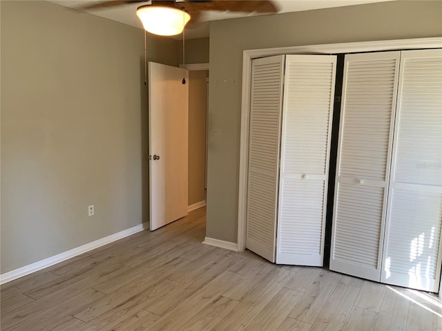 unfurnished bedroom with ceiling fan, light hardwood / wood-style floors, and a closet