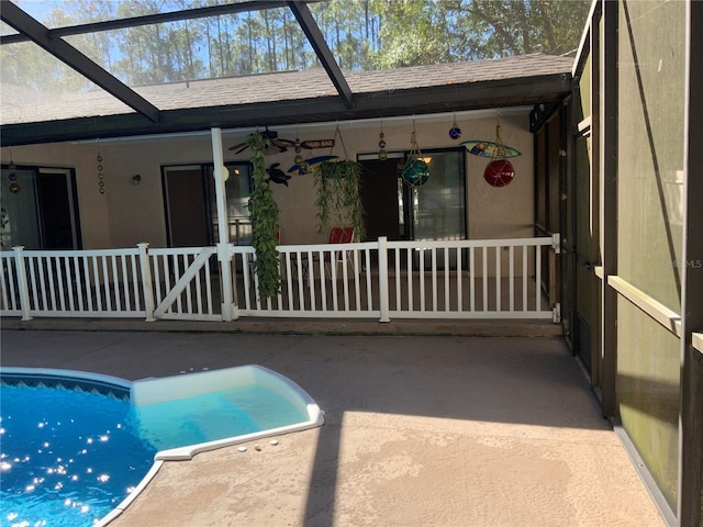 view of swimming pool featuring glass enclosure