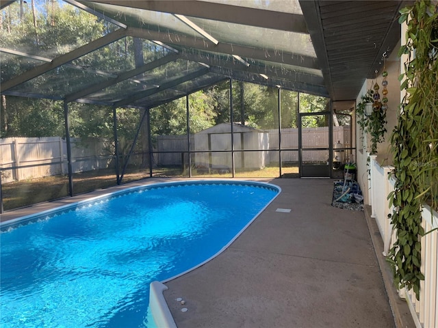 view of pool with glass enclosure and a patio