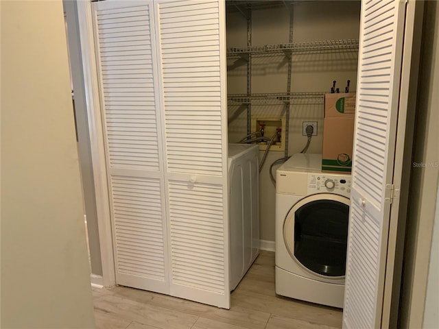 laundry area featuring washer / dryer and light wood-type flooring