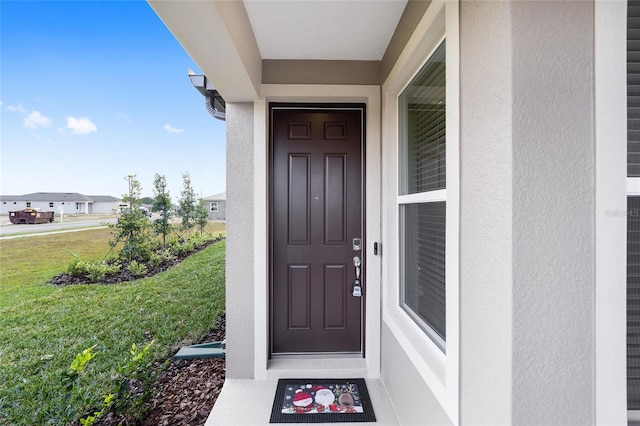 property entrance featuring a lawn