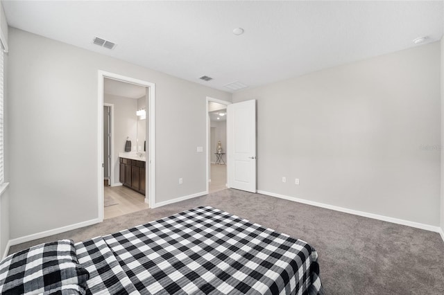 unfurnished bedroom featuring light carpet and ensuite bathroom