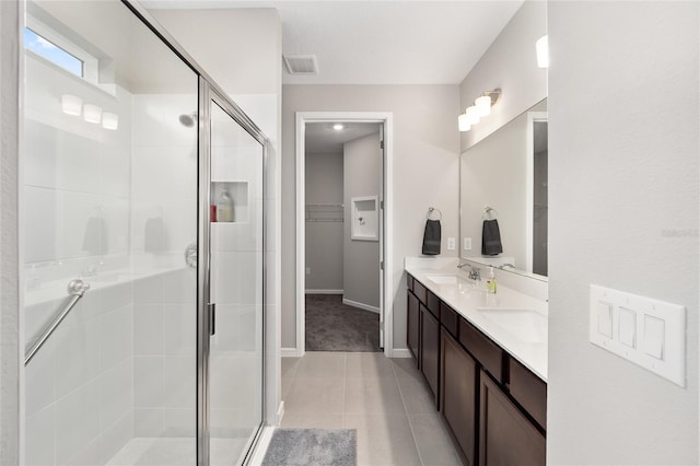 bathroom featuring tile patterned floors, vanity, and a shower with door