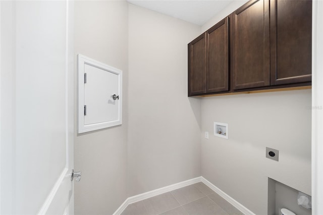 washroom with electric dryer hookup, hookup for a washing machine, light tile patterned flooring, and cabinets