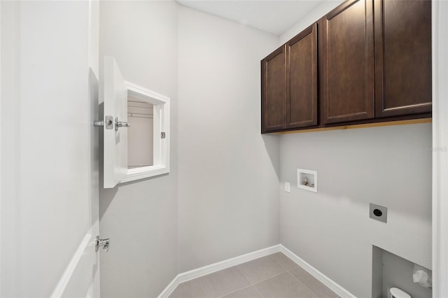 clothes washing area featuring electric dryer hookup, cabinets, light tile patterned floors, and hookup for a washing machine