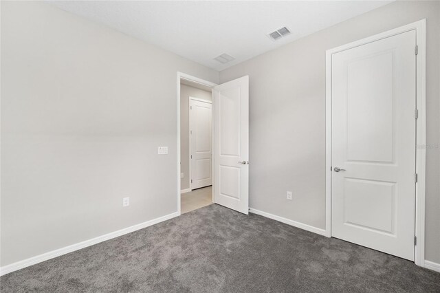 unfurnished bedroom with dark carpet