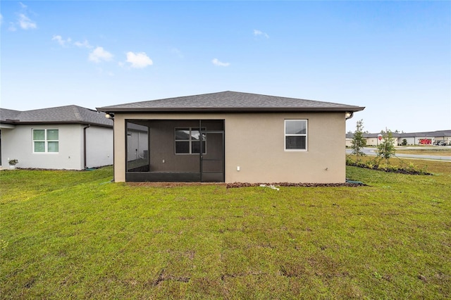 back of property with a lawn and a sunroom