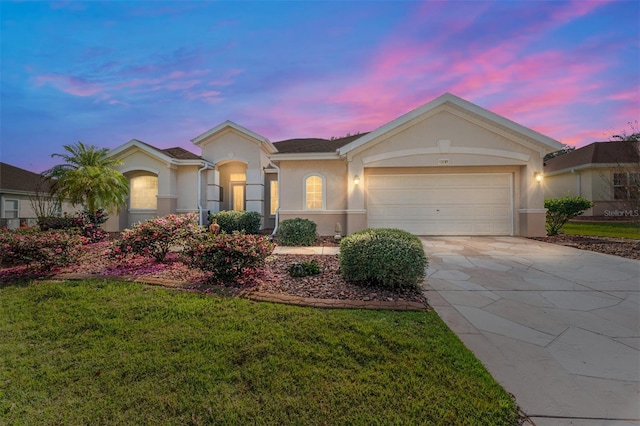 ranch-style home with driveway, a front yard, a garage, and stucco siding