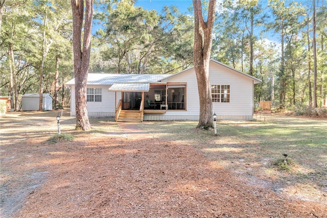 view of front facade with a shed and a sunroom