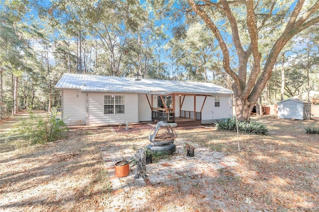 back of property featuring a shed and a deck