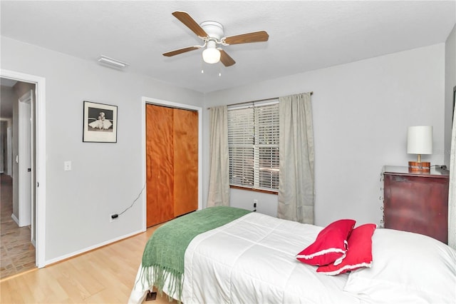 bedroom with light wood-type flooring, a closet, and ceiling fan