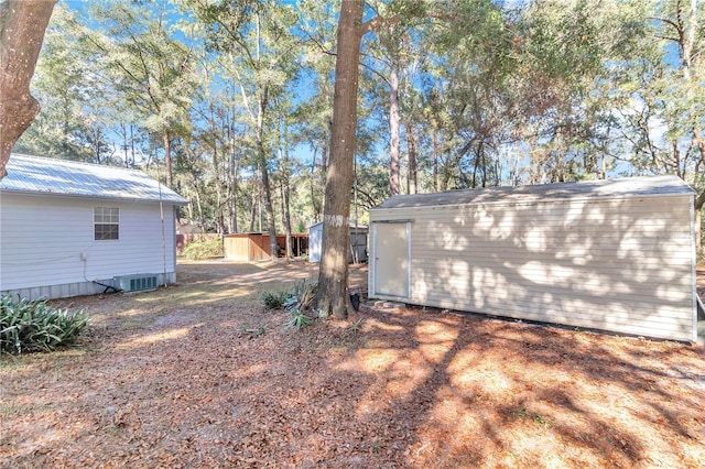 view of yard with central AC unit and a storage unit