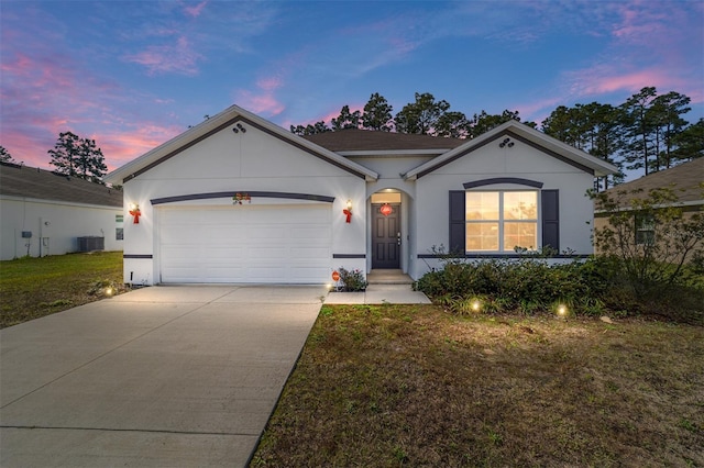 ranch-style house with a yard, central AC, and a garage