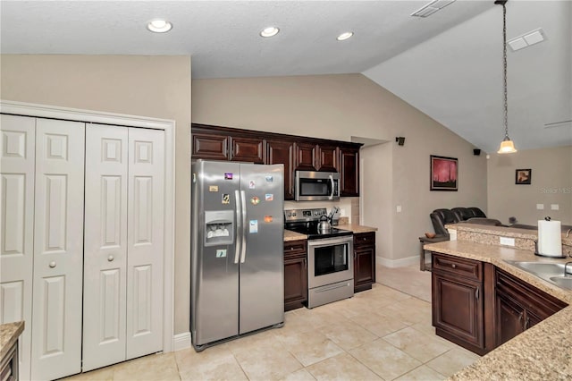 kitchen with appliances with stainless steel finishes, vaulted ceiling, pendant lighting, and light tile patterned flooring