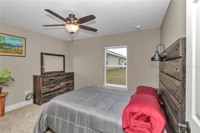 carpeted bedroom featuring a textured ceiling and ceiling fan