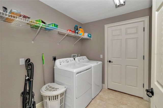 washroom with washer and dryer and light tile patterned floors