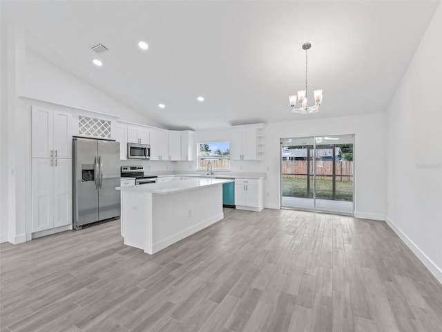 kitchen with a center island, decorative light fixtures, white cabinetry, stainless steel appliances, and a chandelier