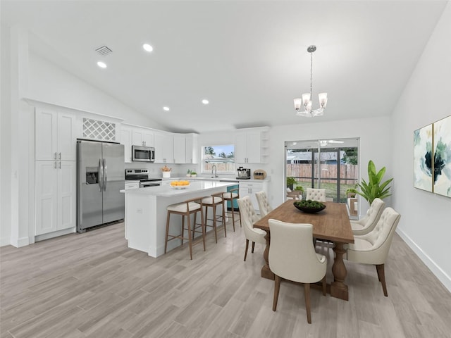 dining room featuring plenty of natural light, light hardwood / wood-style floors, and lofted ceiling