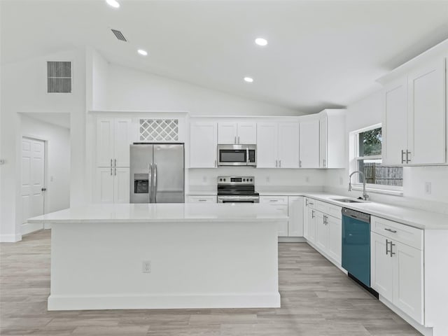 kitchen with white cabinets, a center island, stainless steel appliances, and sink