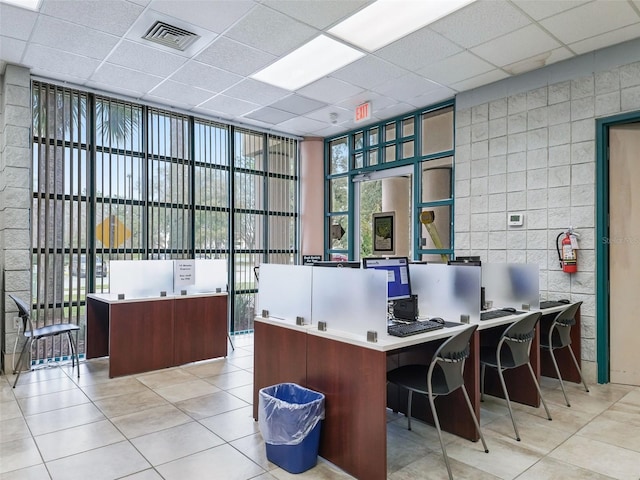 tiled office space with a paneled ceiling