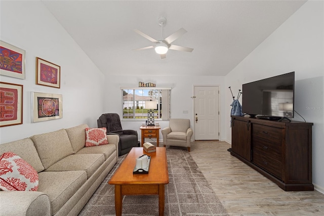 living room with ceiling fan, light hardwood / wood-style flooring, and vaulted ceiling