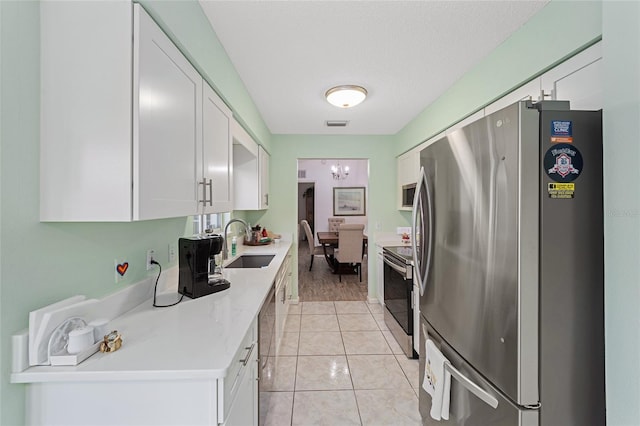 kitchen with white cabinetry, sink, light tile patterned floors, and stainless steel appliances