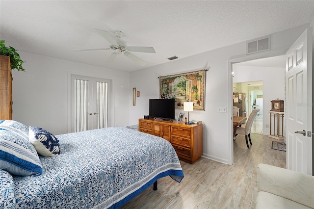 bedroom featuring a textured ceiling, light hardwood / wood-style flooring, and ceiling fan