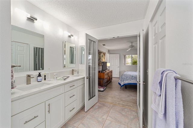 bathroom featuring tile patterned flooring, ceiling fan, a textured ceiling, and vanity