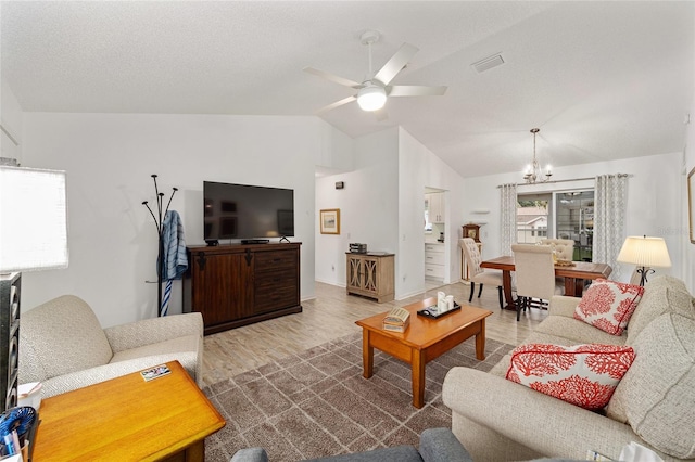 living room featuring wood-type flooring, ceiling fan with notable chandelier, and lofted ceiling