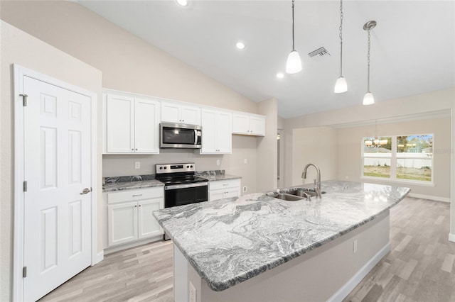 kitchen featuring white cabinetry, sink, stainless steel appliances, vaulted ceiling, and a kitchen island with sink