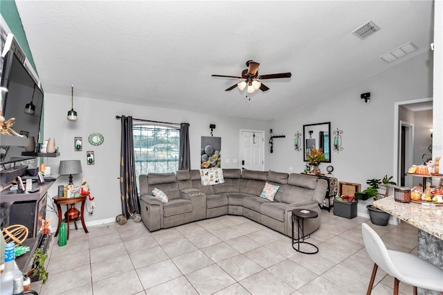 living room with light tile patterned floors, a textured ceiling, ceiling fan, and lofted ceiling