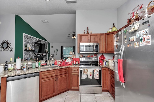 kitchen with light stone countertops, sink, ceiling fan, stainless steel appliances, and light tile patterned floors