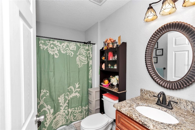 bathroom featuring vanity, toilet, and a textured ceiling