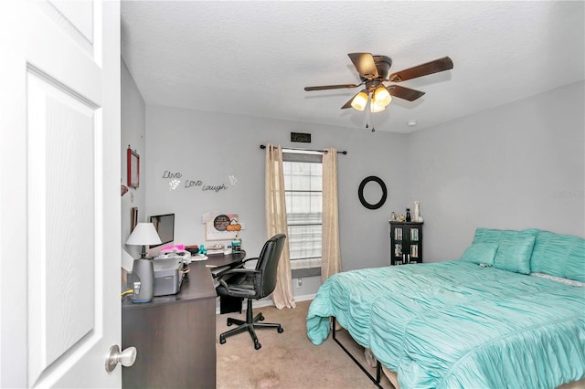 bedroom with ceiling fan, light colored carpet, and a textured ceiling