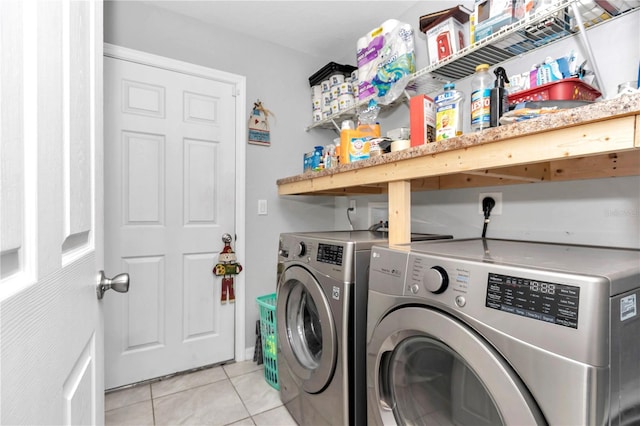 clothes washing area with washing machine and dryer and light tile patterned floors