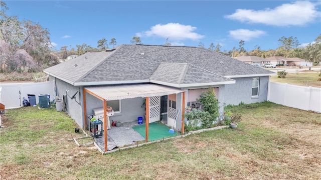 rear view of house featuring a lawn, a patio, and central AC