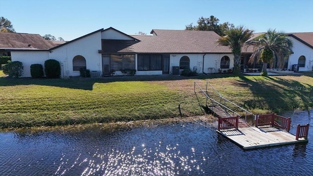 back of property featuring a water view and a yard